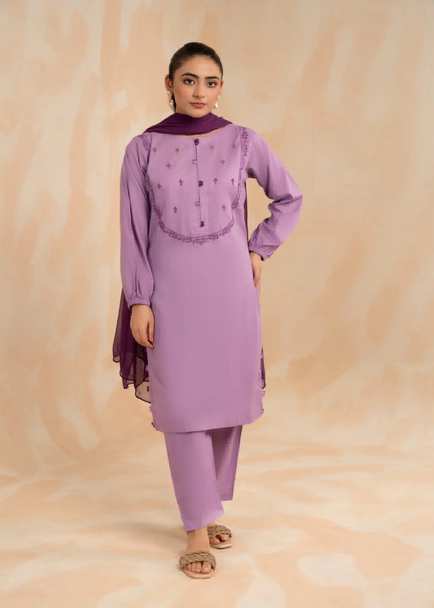 Woman wearing a floor-length pink floral dress with long sleeves